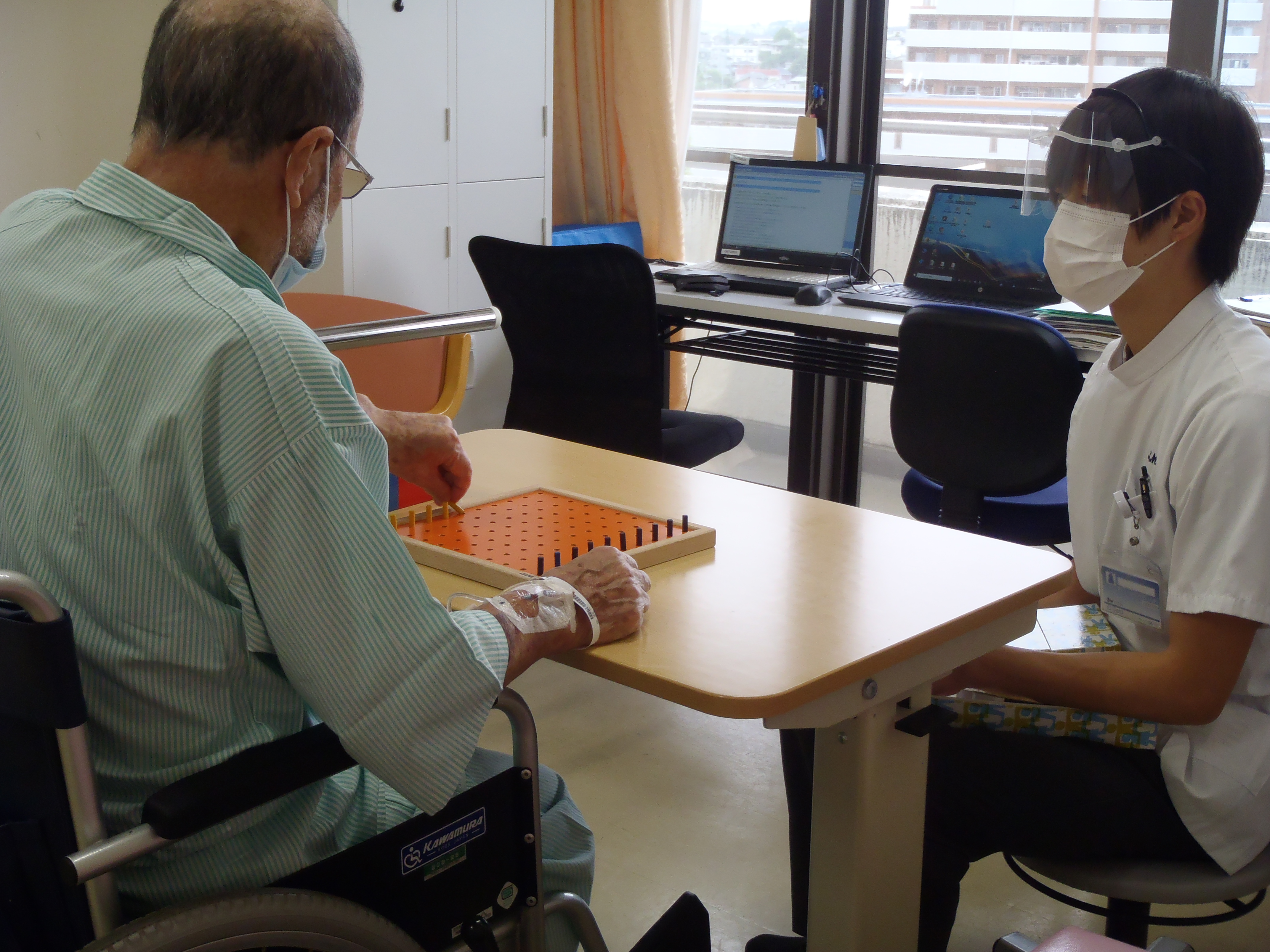 日常動作の訓練を行う作業療法士と患者
