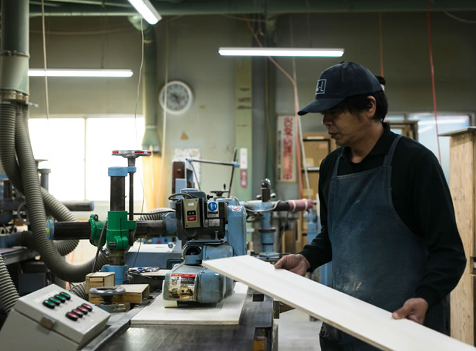 公式製造工場ページの、引き出し材を加工する職人の写真