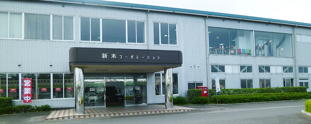 公式会社案内に掲載された、新木コーポレーションの表記がある本社・工場の正面外観