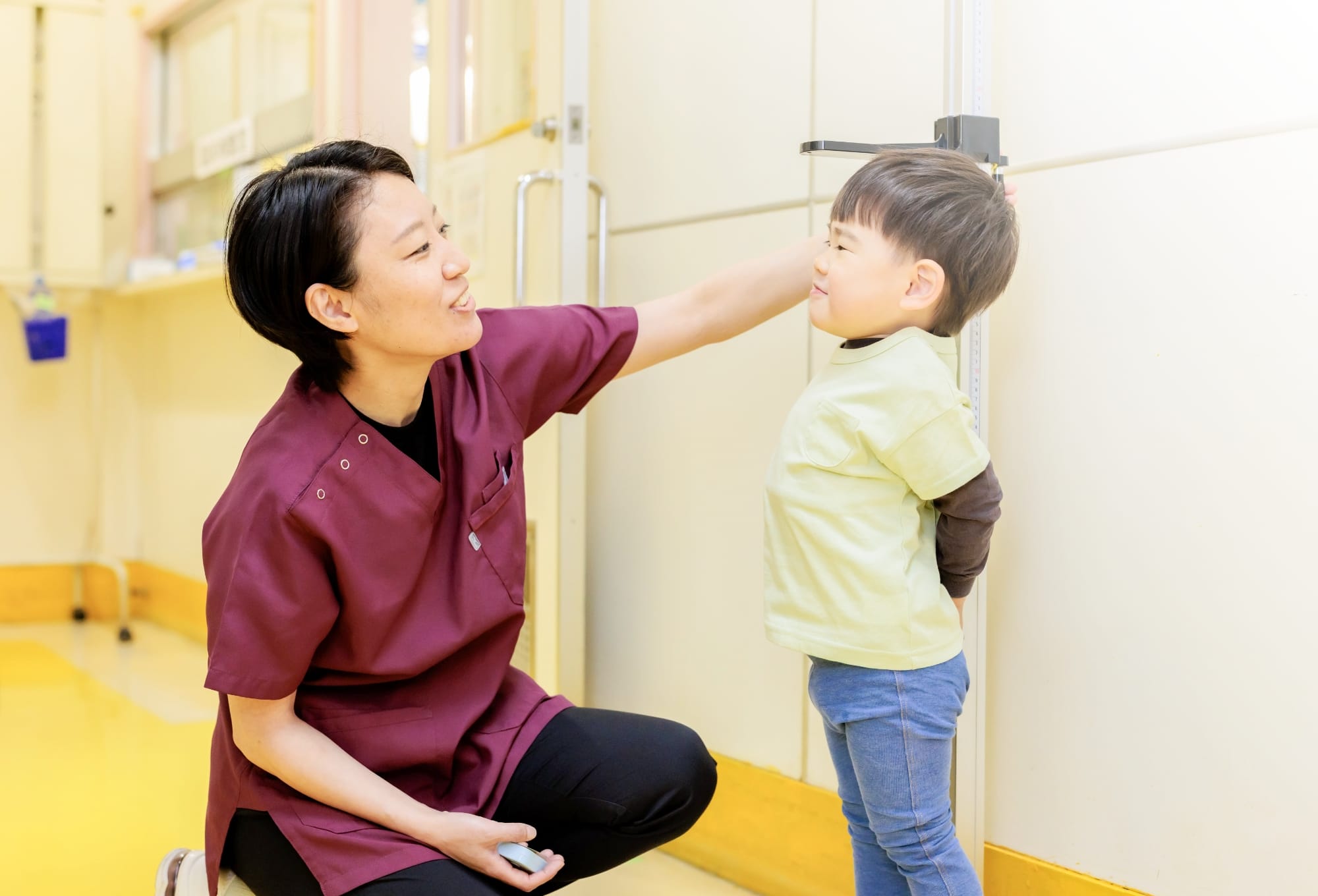 医療スタッフが子どもの身長を測る場面