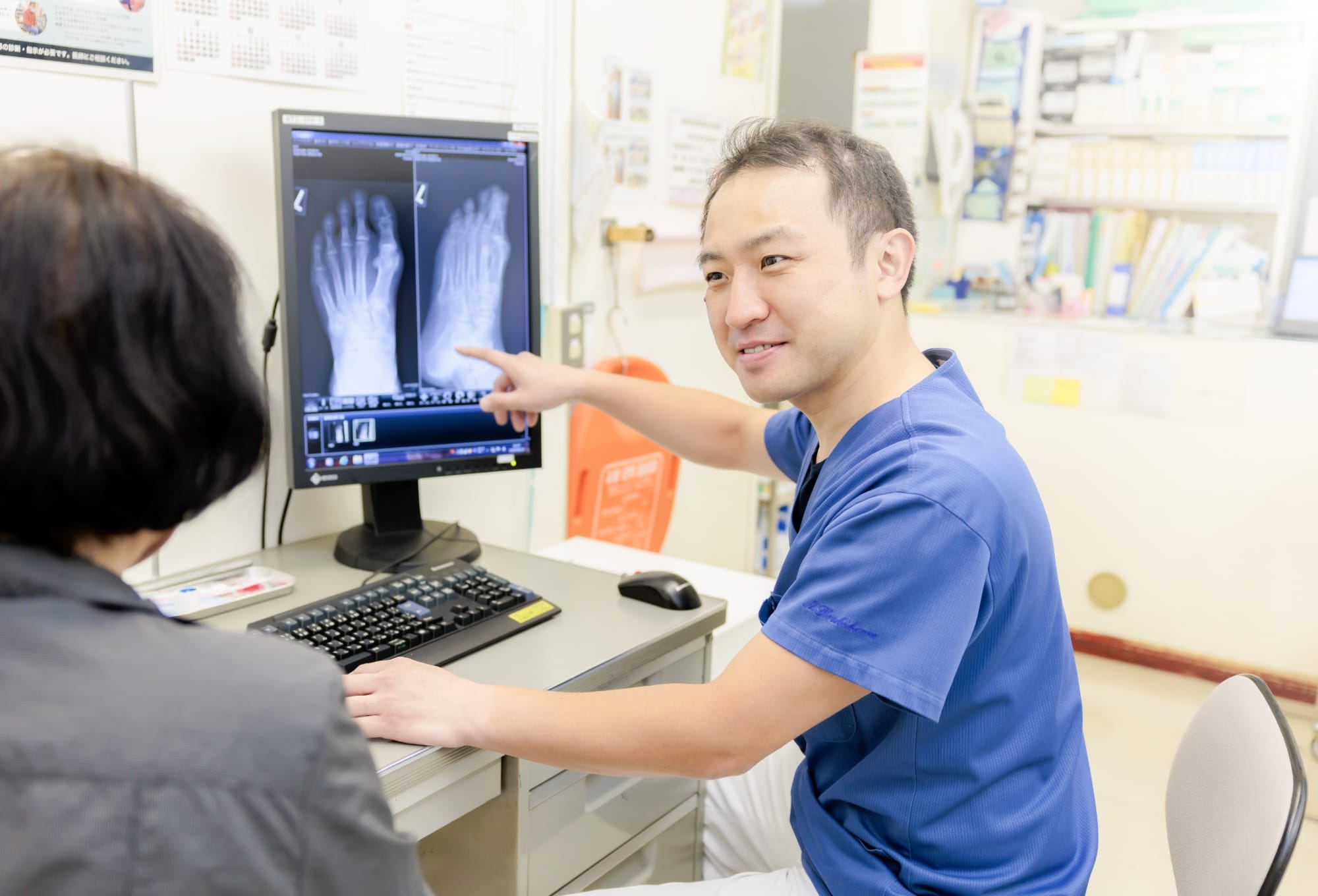 医師が画像を示して患者に説明する場面