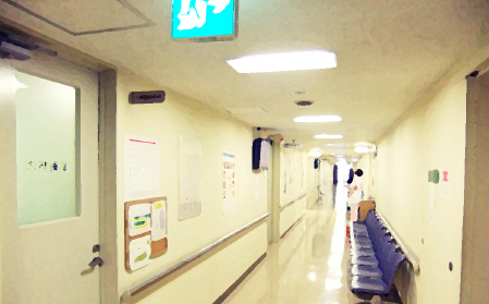公式サイトの案内背景として掲載された無人の院内通路と待合いす