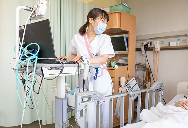 病室で医療機器を確認する東京都立荏原病院の看護師