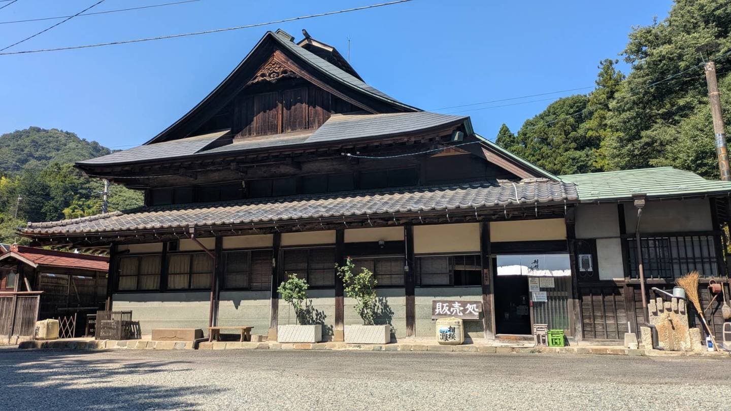 山あいに建つ久保田酒造の木造母屋と販売処