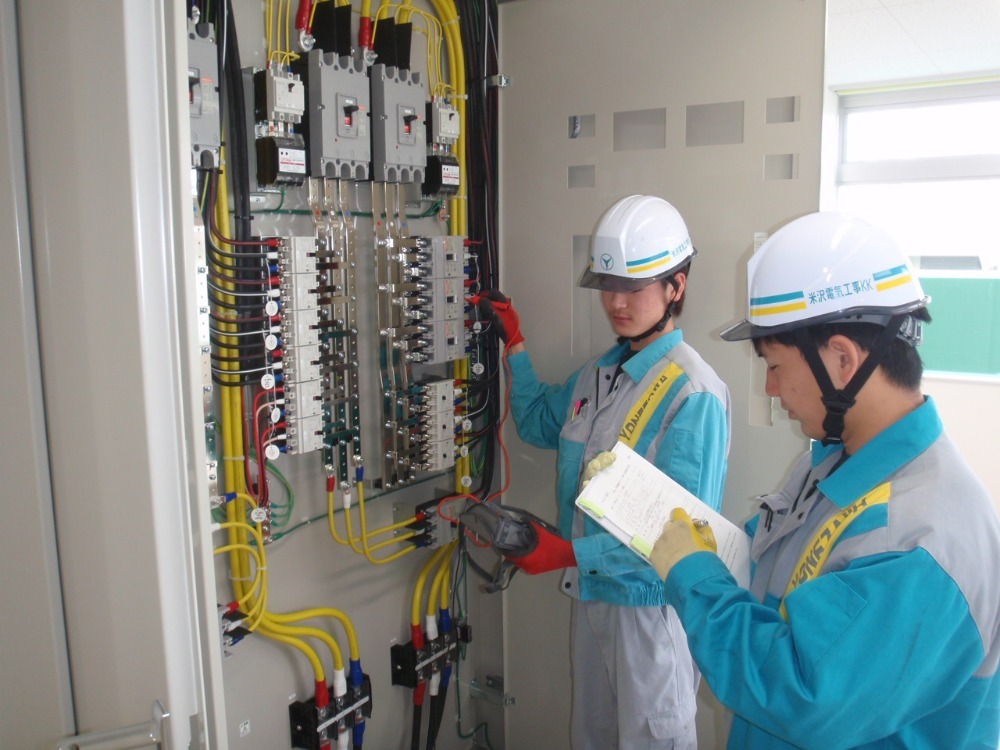 電気設備の点検を行う2人の作業員