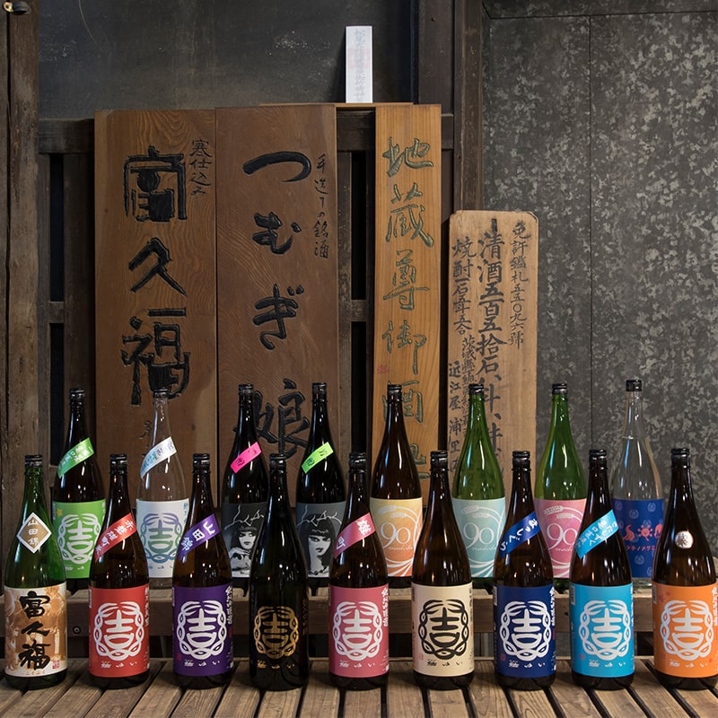 歴史ある蔵内に並ぶ結ゆいと富久福の酒瓶