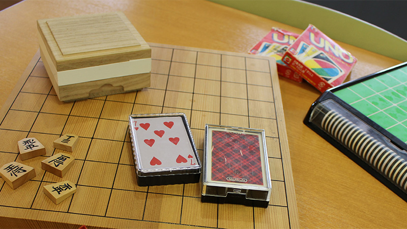 将棋やカードなどの活動用具が置かれたデイケアのテーブル