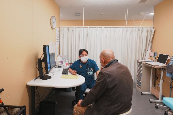 診察室で患者と向き合う医療スタッフ