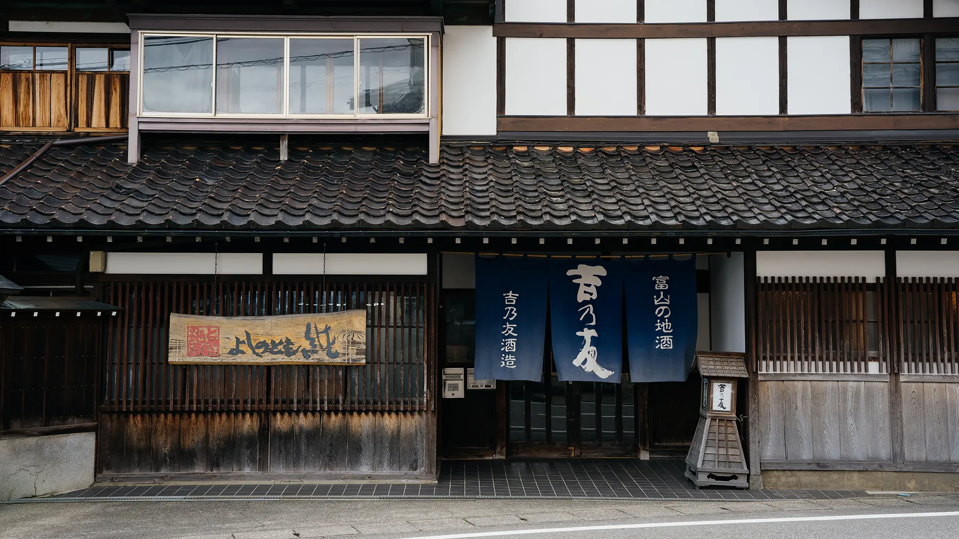 公式会社紹介ページに掲載された、吉乃友酒造の暖簾と看板が見える建物正面